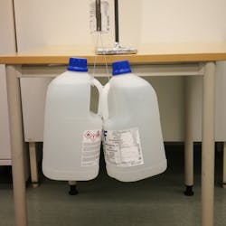 Impressive Adhesion Figure 2. Material held two pieces of steel together strongly enough to suspend two jugs weighing a total of 16 kg for over a month. Impressive Adhesion Figure 2. Material held two pieces of steel together strongly enough to suspend two jugs weighing a total of 16 kg for over a month.