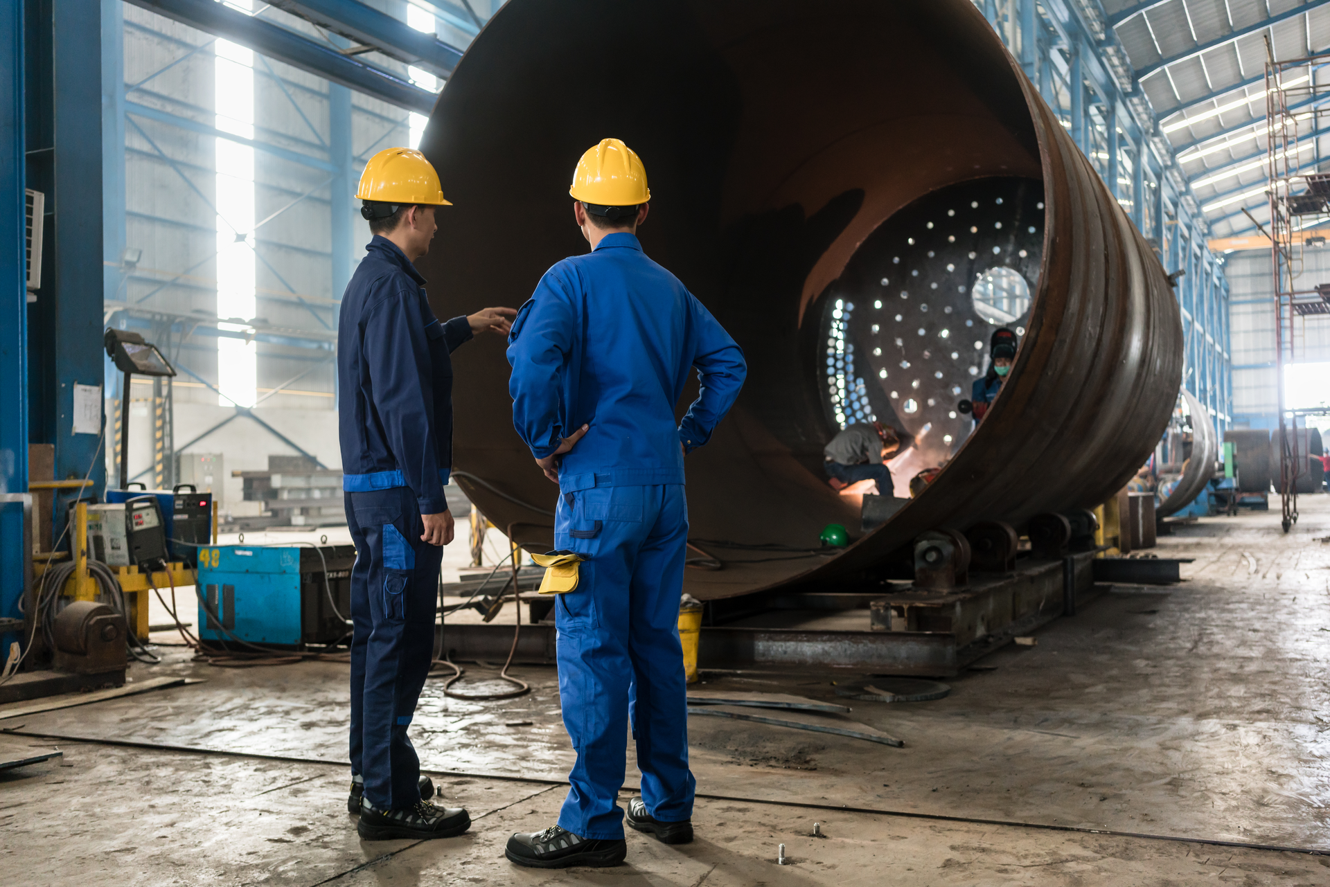 two workers inspect a vessel