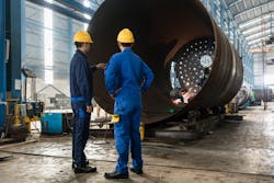 two workers inspect a vessel two workers inspect a vessel