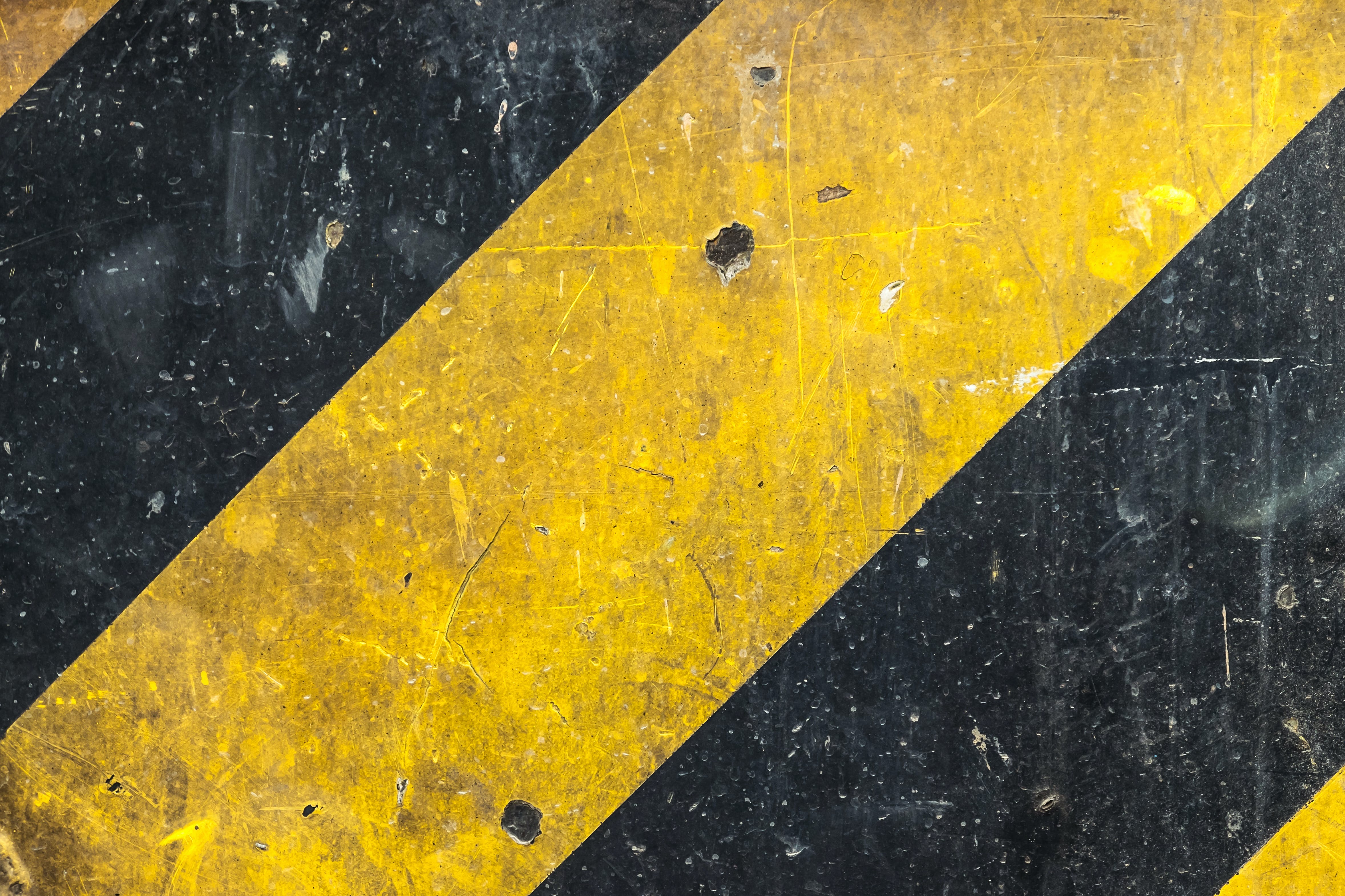 Metal texture with caution sign, scratched surface