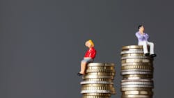 Miniature Figure Of A Man And Women Sit On Stacks Of Coin, But Female's Stack Of Coins Is Less Than The Male's Miniature Figure Of A Man And Women Sit On Stacks Of Coin, But Female's Stack Of Coins Is Less Than The Male's