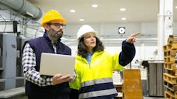 A man and women wearing hard hats and safety apparel A man and women wearing hard hats and safety apparel