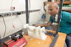 Sujit Bidhar, an engineer and researcher at Fermilab, works on an electrospinning experiment. The technique for producing ceramic nanofibers could make the materials more accessible and affordable
