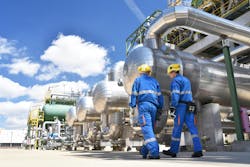 workers in an industrial plant for the production and processing of crude oil workers in an industrial plant for the production and processing of crude oil