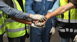 Group of technician engineer or worker in protective uniform with hardhat standing and stacking hands