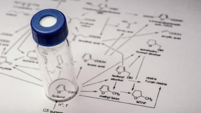 Sample vial on paper with chemical formula
