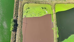 aerial view of an industrial wastewater treatment pond with algae aerial view of an industrial wastewater treatment pond with algae