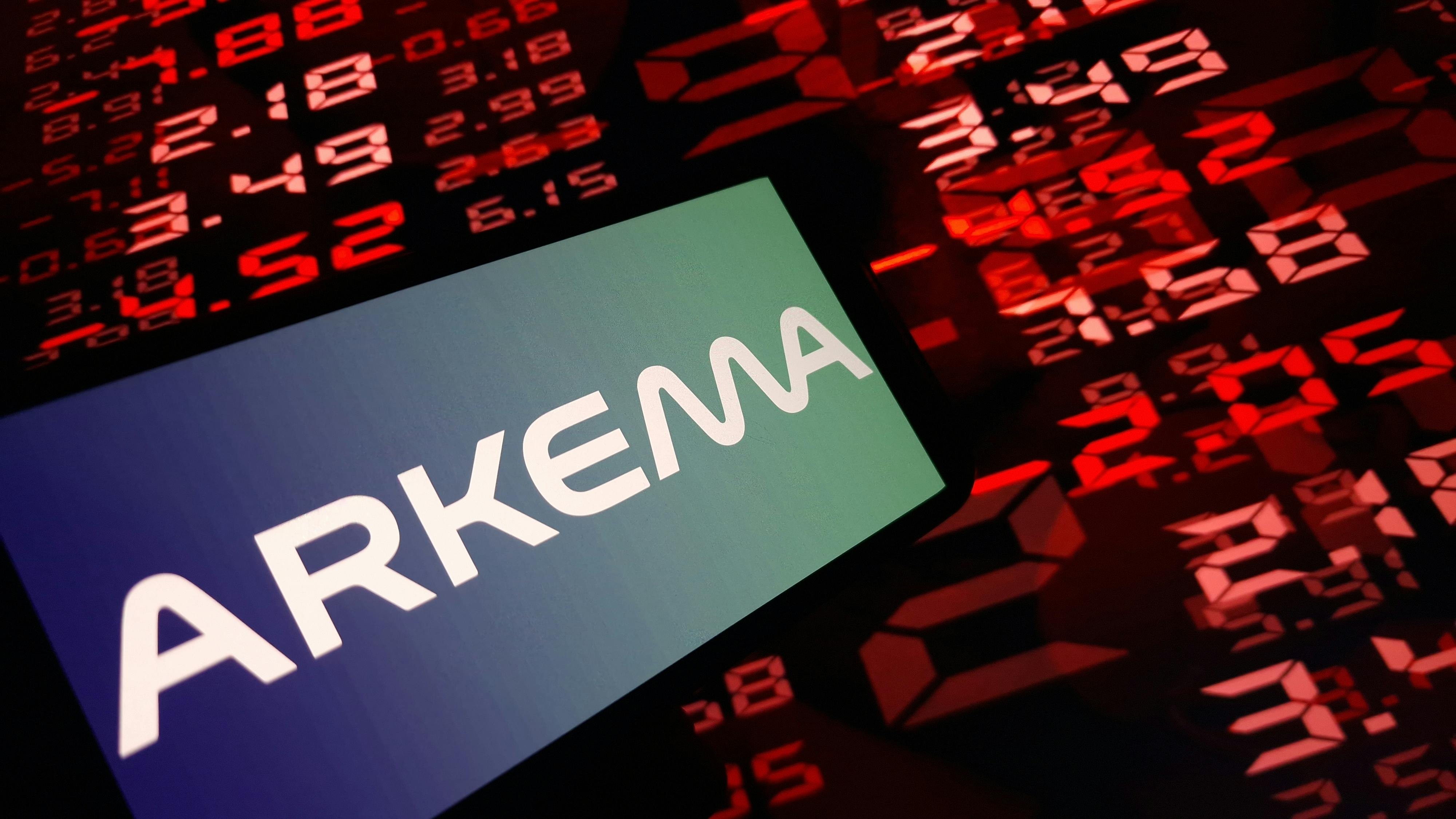 Arkema logo on smartphone display with red digital stock numbers in background