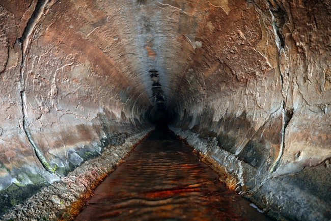 Filth flowing out from sewage pipe angle shot