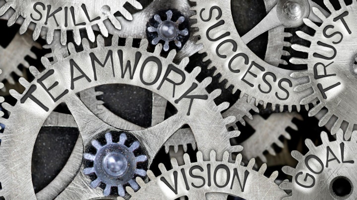 Words Teamwork, Vision, Goal, Trust, Success, Skill, Partner displayed on gears