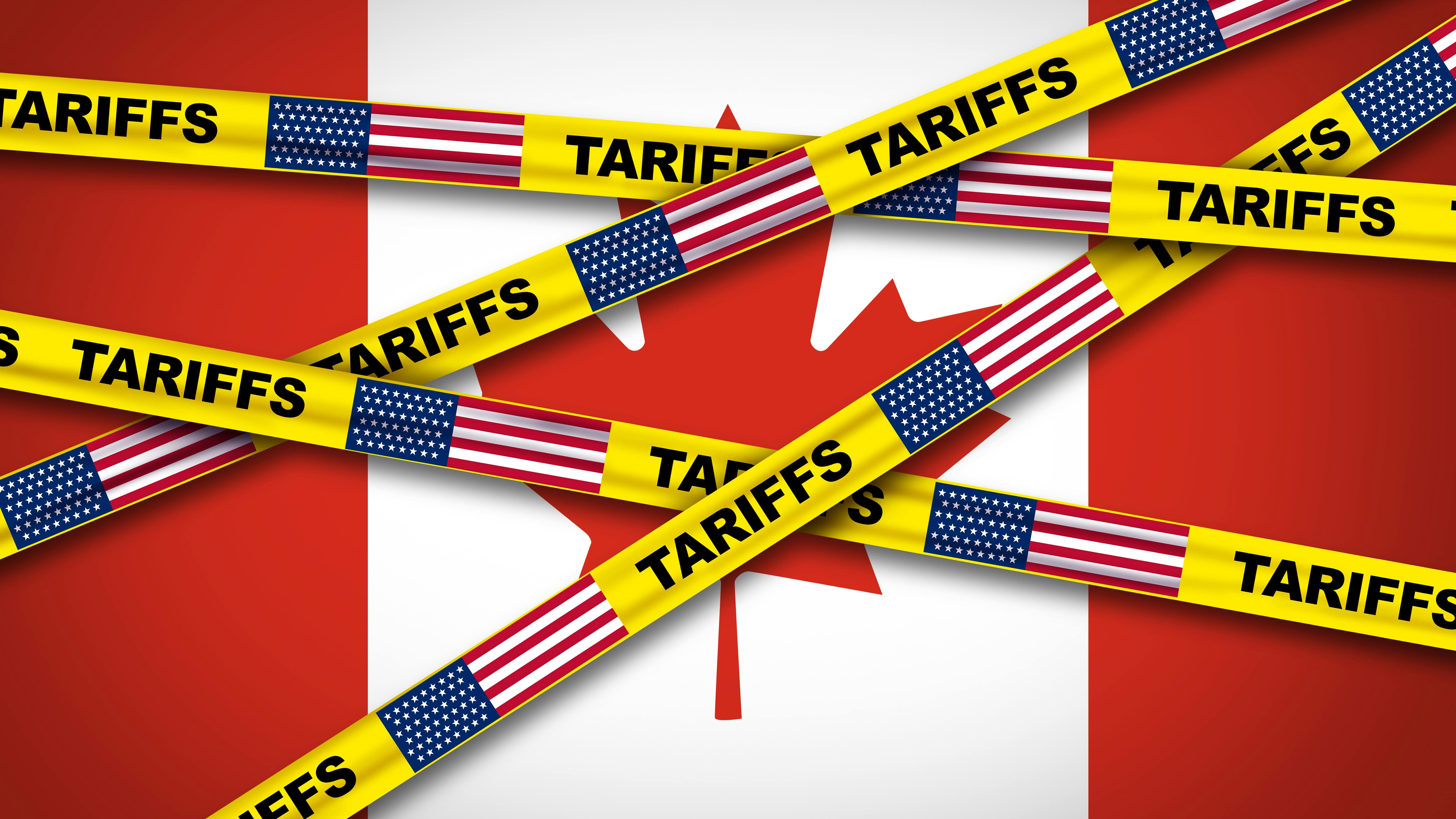 Canadian flag covered by caution tape displaying US flag and the word tariffs