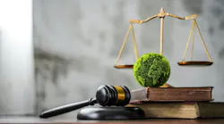 sustainable environmental regulation and laws - green globe on law books with law scale in background
