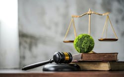 sustainable environmental regulation and laws - green globe on law books with law scale in background sustainable environmental regulation and laws - green globe on law books with law scale in background