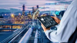 Hands holding tablet with Chemical plant blurred in background Hands holding tablet with Chemical plant blurred in background