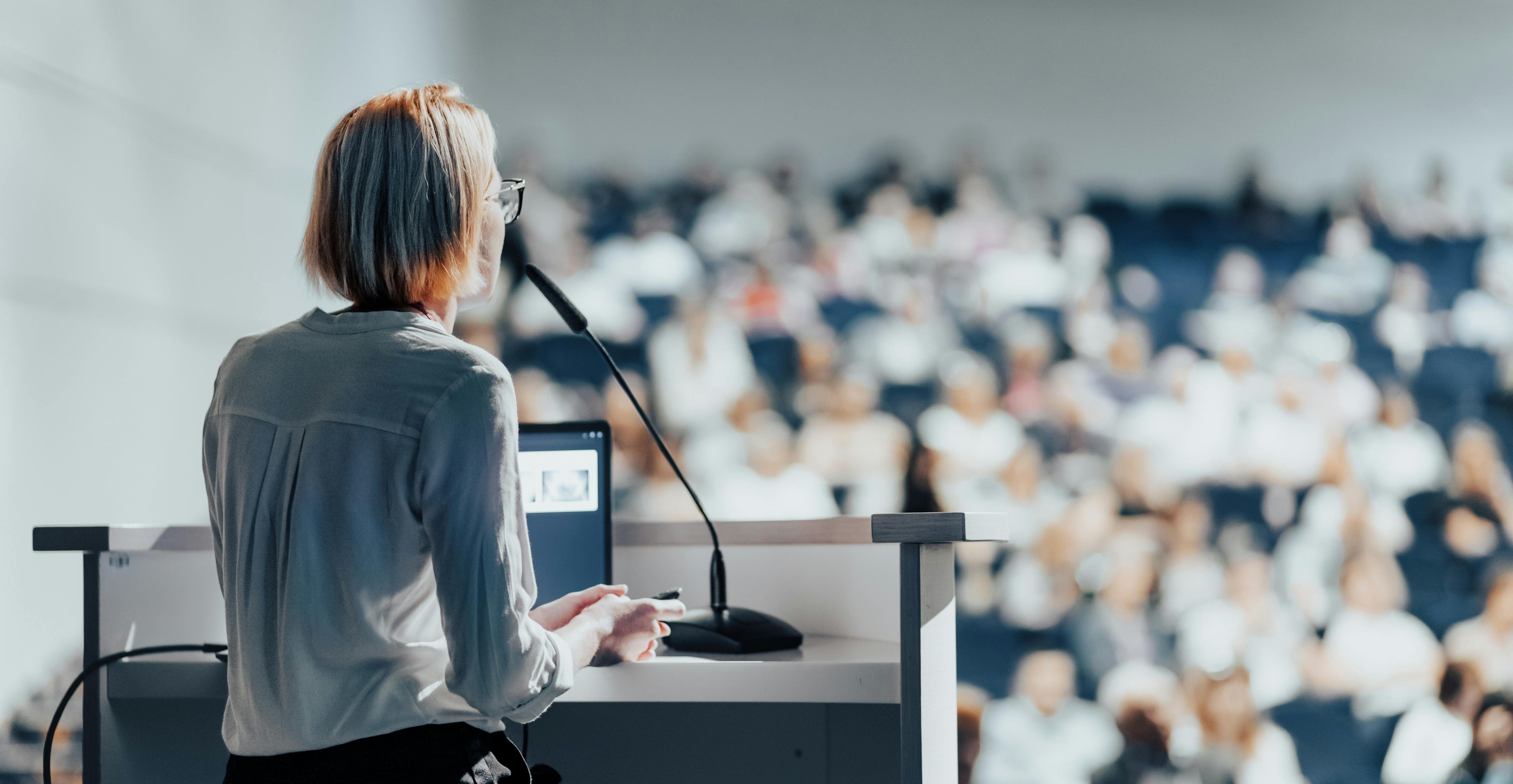 Female speaker giving a talk on corporate business conference.