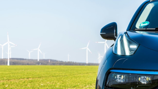 automobile and windfarm in the background