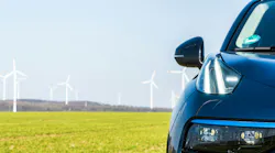 automobile and windfarm in the background