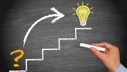 hand holds chalk in front of chalkboard with drawing of rudimentary stairs where bottom step has a question mark, an arrow points to top step that has an illuminated lightbulb hand holds chalk in front of chalkboard with drawing of rudimentary stairs where bottom step has a question mark, an arrow points to top step that has an illuminated lightbulb