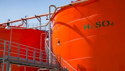 Orange metal storage tanks with sulfuric acid and its formula on tank Orange metal storage tanks with sulfuric acid and its formula on tank