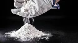 gloved hand cups white powder dropping it into a pile