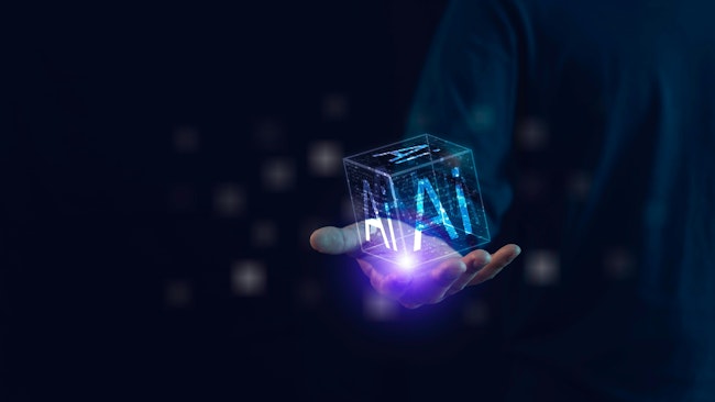 open hand holding digitally formed cube with AI written on sides
