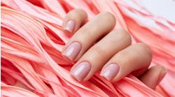 Close-up woman's manicured hand holds a pink leaf Close-up woman's manicured hand holds a pink leaf