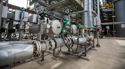 Oil refinery plant. Close up of equipment. Pipes in background.