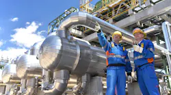 group of industrial workers in a refinery - oil processing equipment and machinery