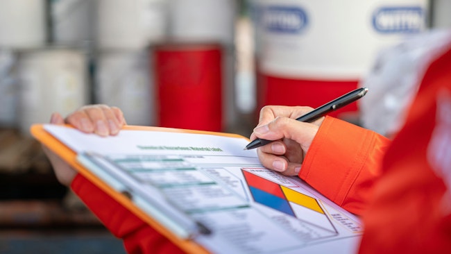 worker checking off safety protocols on clipboard