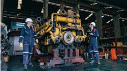 Engineers work on large diesel engine Engineers work on large diesel engine