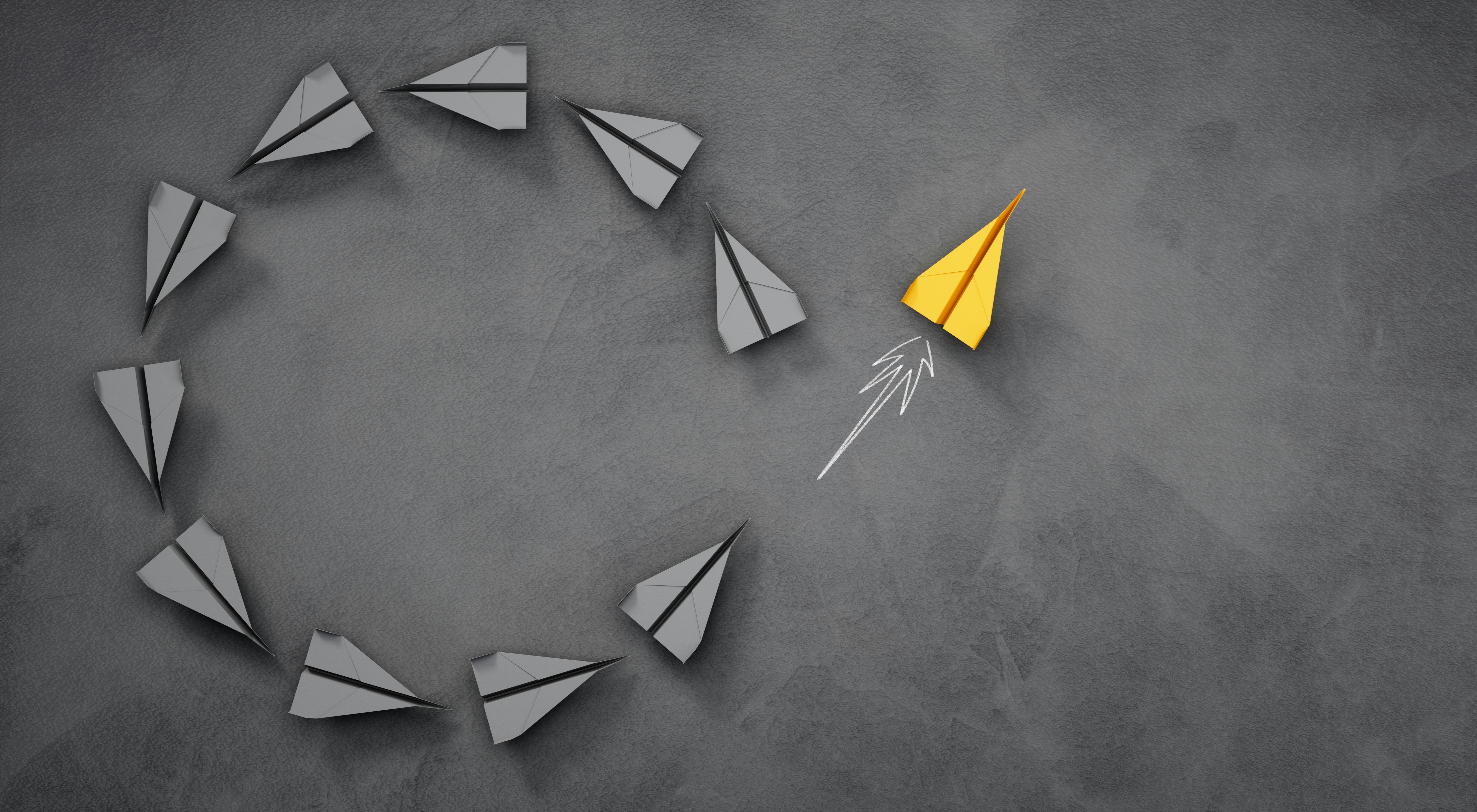 paper airplanes form a circle shape with one flying away from it