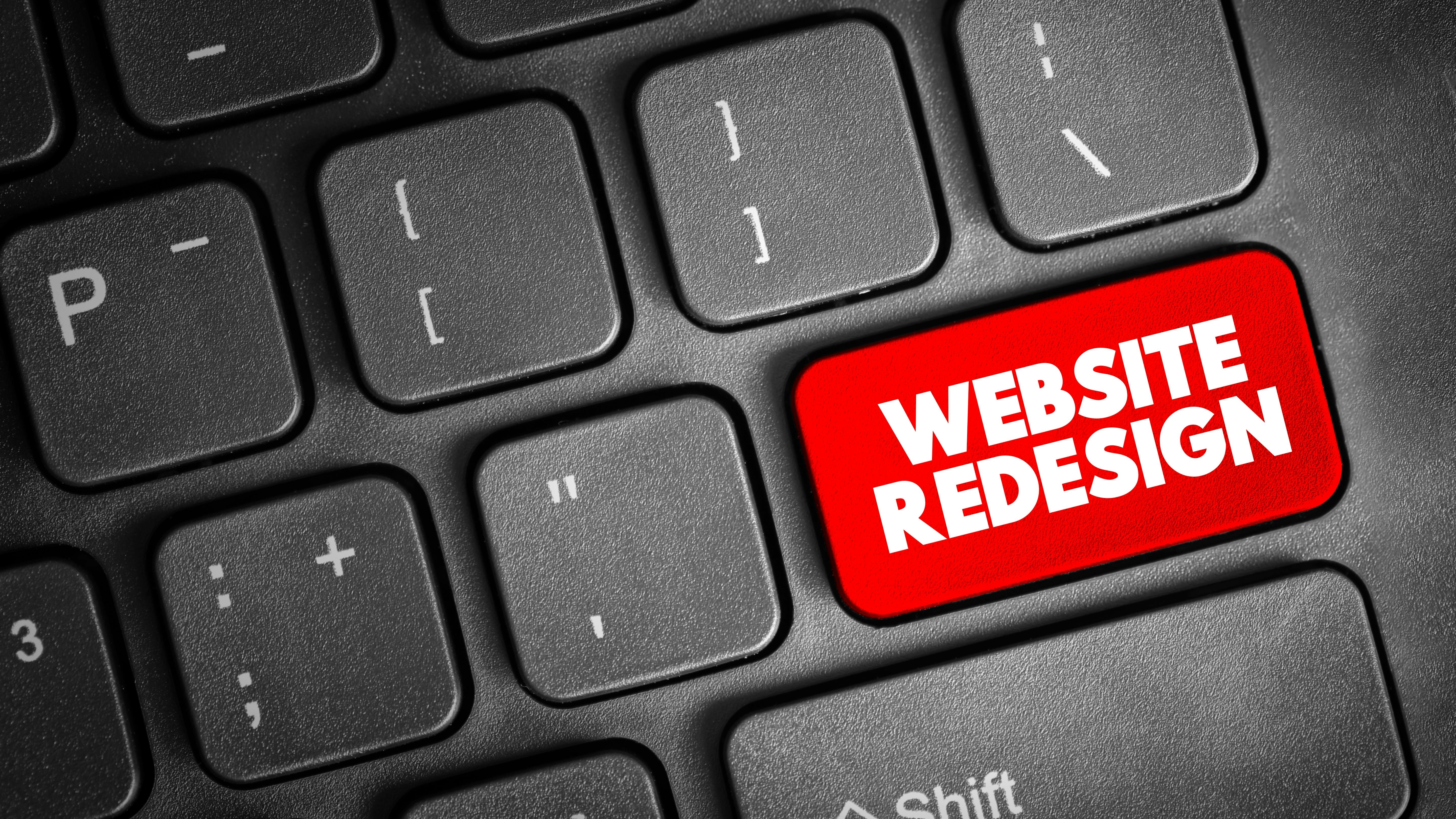 where the enter button sits on a keyboard a red website redesign button is surrounded by all other keys in black.