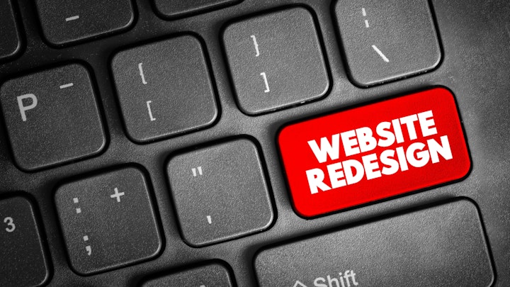 where the enter button sits on a keyboard a red website redesign button is surrounded by all other keys in black.