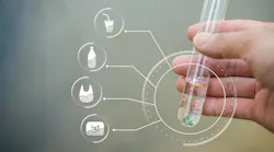 hand holds test tube filled with clear liquid and microplastics