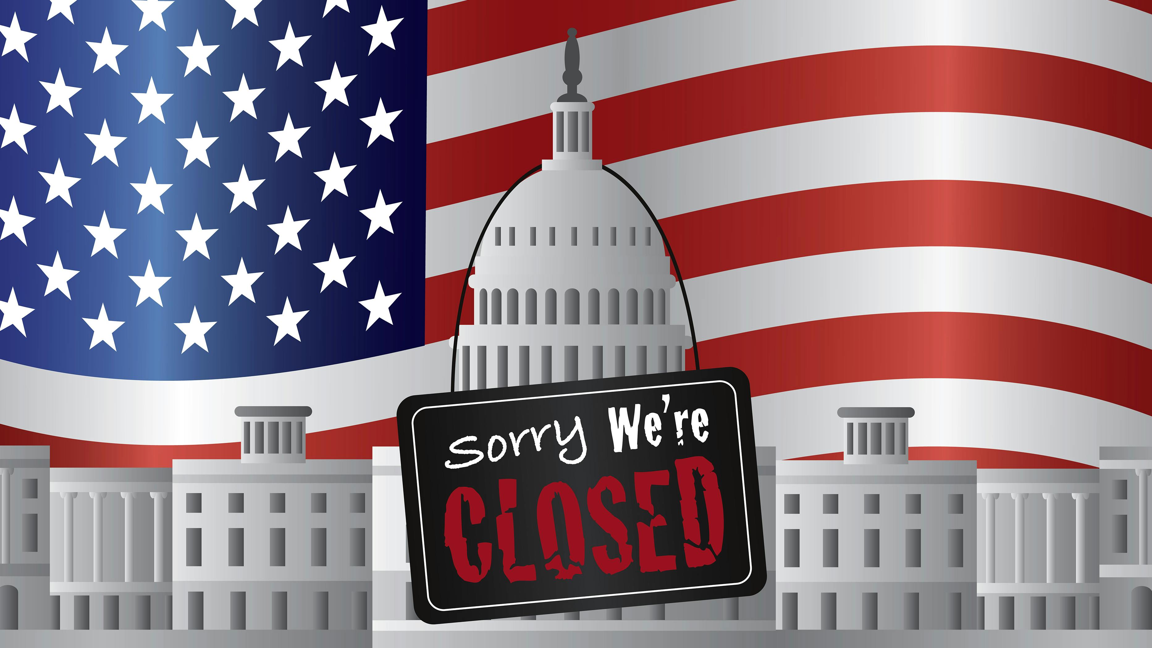 US government building with a Sorry we're closed sign and US flag in background