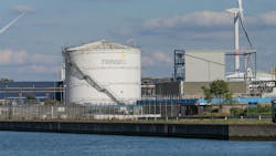 Industrial view of the Trinseo chemical plant with storage tank, wind turbines, and canal water in the foreground under a partly cloudy blue sky. Tessenderlo-Ham, Belgium Industrial view of the Trinseo chemical plant with storage tank, wind turbines, and canal water in the foreground under a partly cloudy blue sky. Tessenderlo-Ham, Belgium