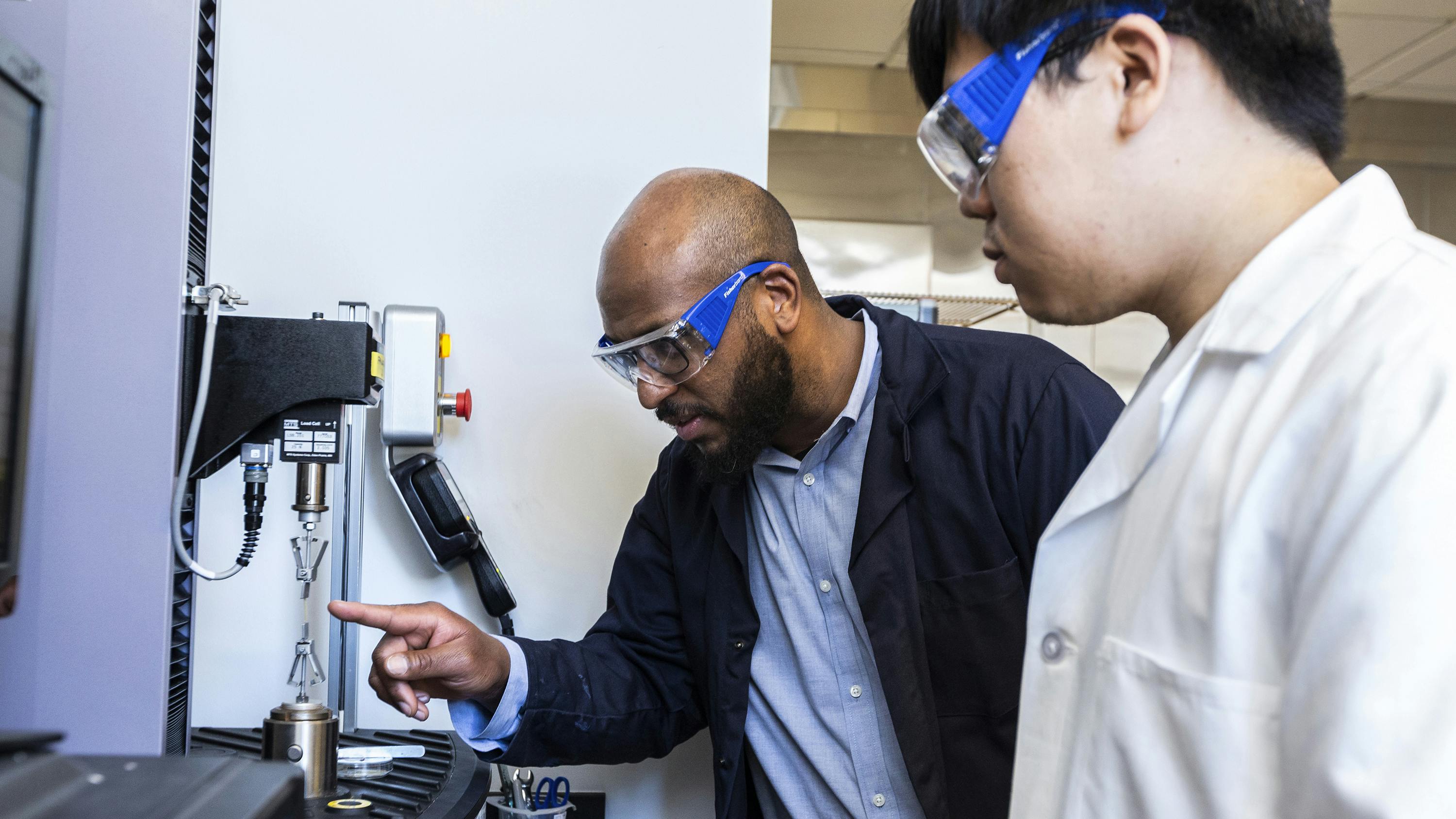 In his lab, professor Marcus Foston of Washington University&rsquo;s McKelvey School of Engineering and Applied Science, inspects a bioplastic sample with Ph.D. student Jerry Wang, right. (Jerry Naunheim/Washington University in St. Louis/TNS)