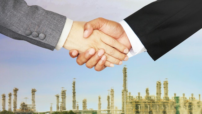 business handshake with chemical plant in background