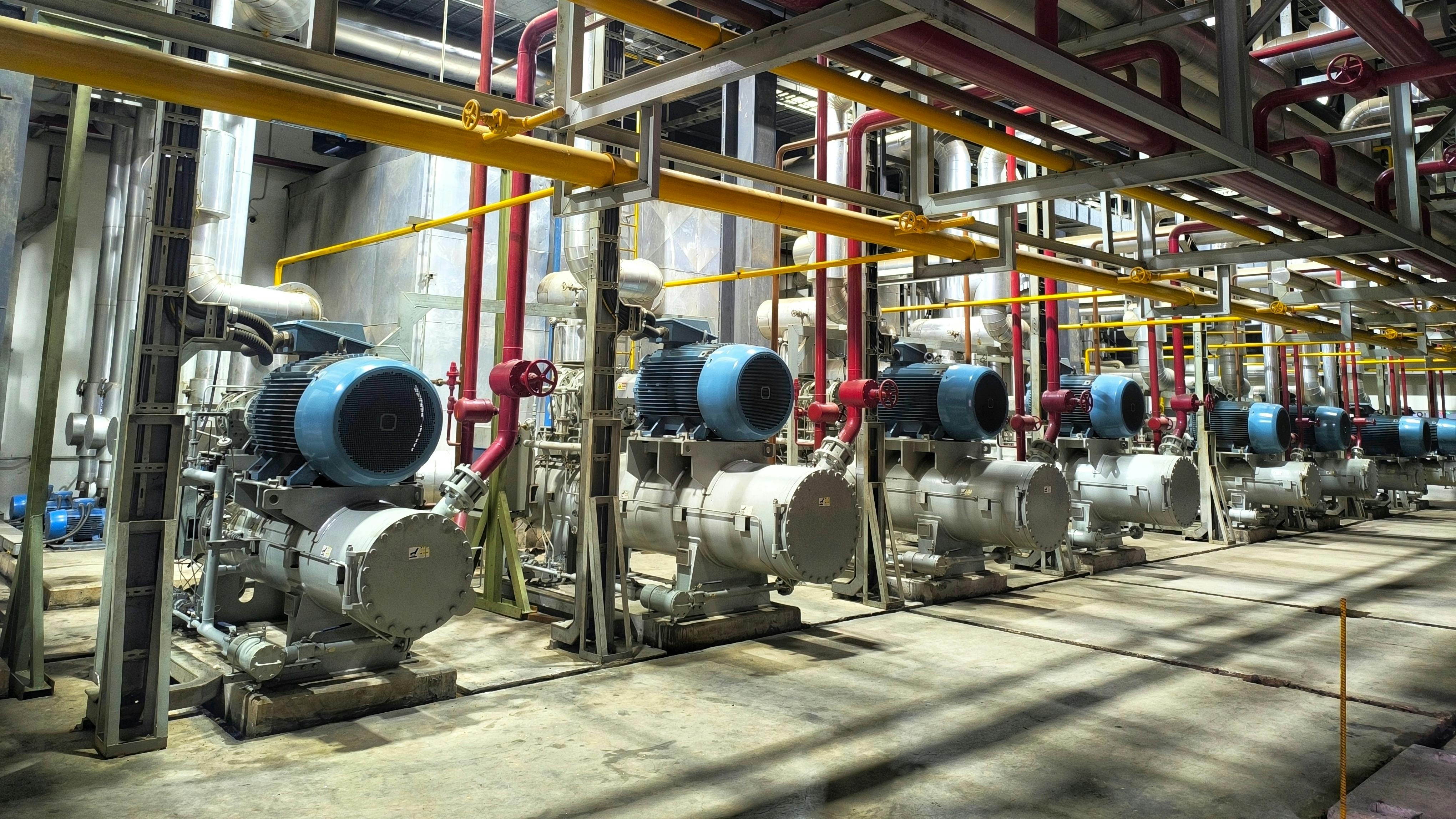 row of reciprocating compressors in a an industrial plant