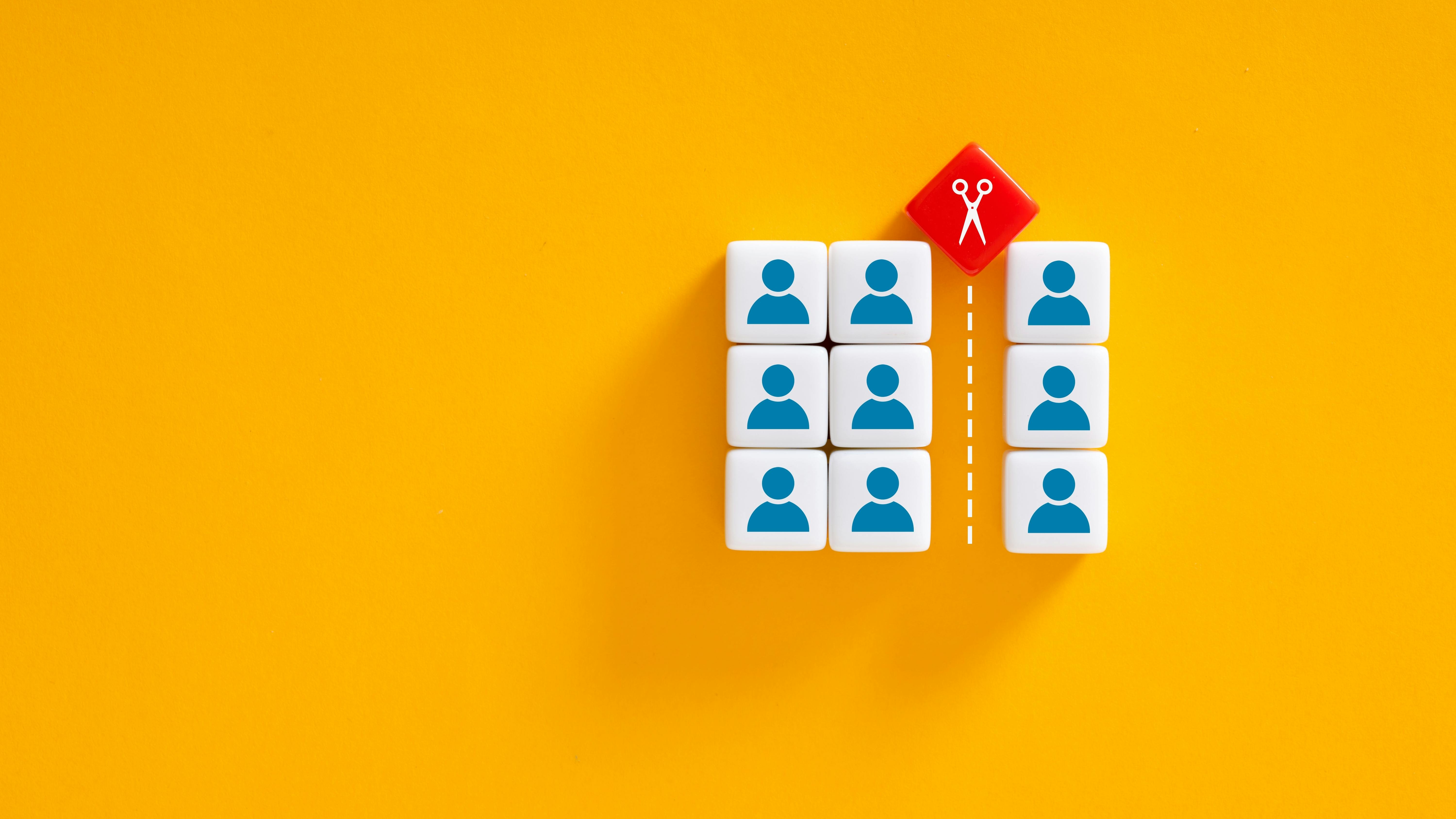 Job cuts, employee layoffs, firings or downsizing. Scissors dividing individuals positioned on colorful blocks