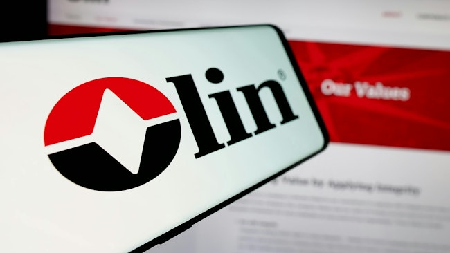 Cellphone with logo of American chemicals company Olin Corporation on screen in front of business website.