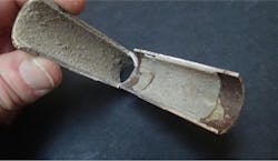 Cross section of a steam surface condenser tube with calcium carbonate scale. Cross section of a steam surface condenser tube with calcium carbonate scale.