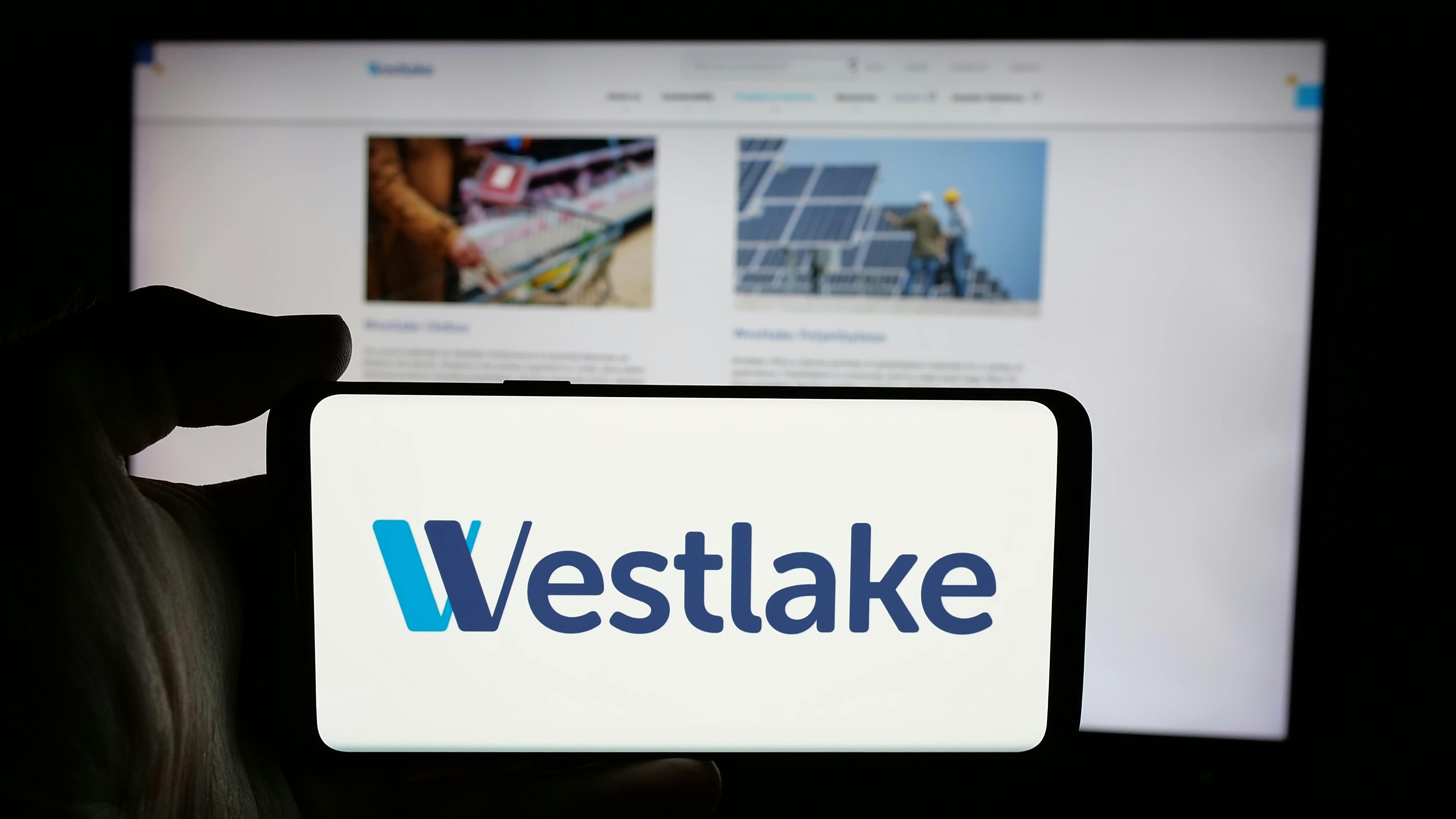 Westlake logo on phone screen with company website displayed on computer screen in background