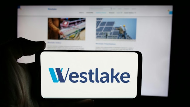 Westlake logo on phone screen with company website displayed on computer screen in background