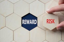 hand holds a hexagonal tile with the word risk. in the background hexagonal tiles surround empty slot that reveals the word reward hand holds a hexagonal tile with the word risk. in the background hexagonal tiles surround empty slot that reveals the word reward
