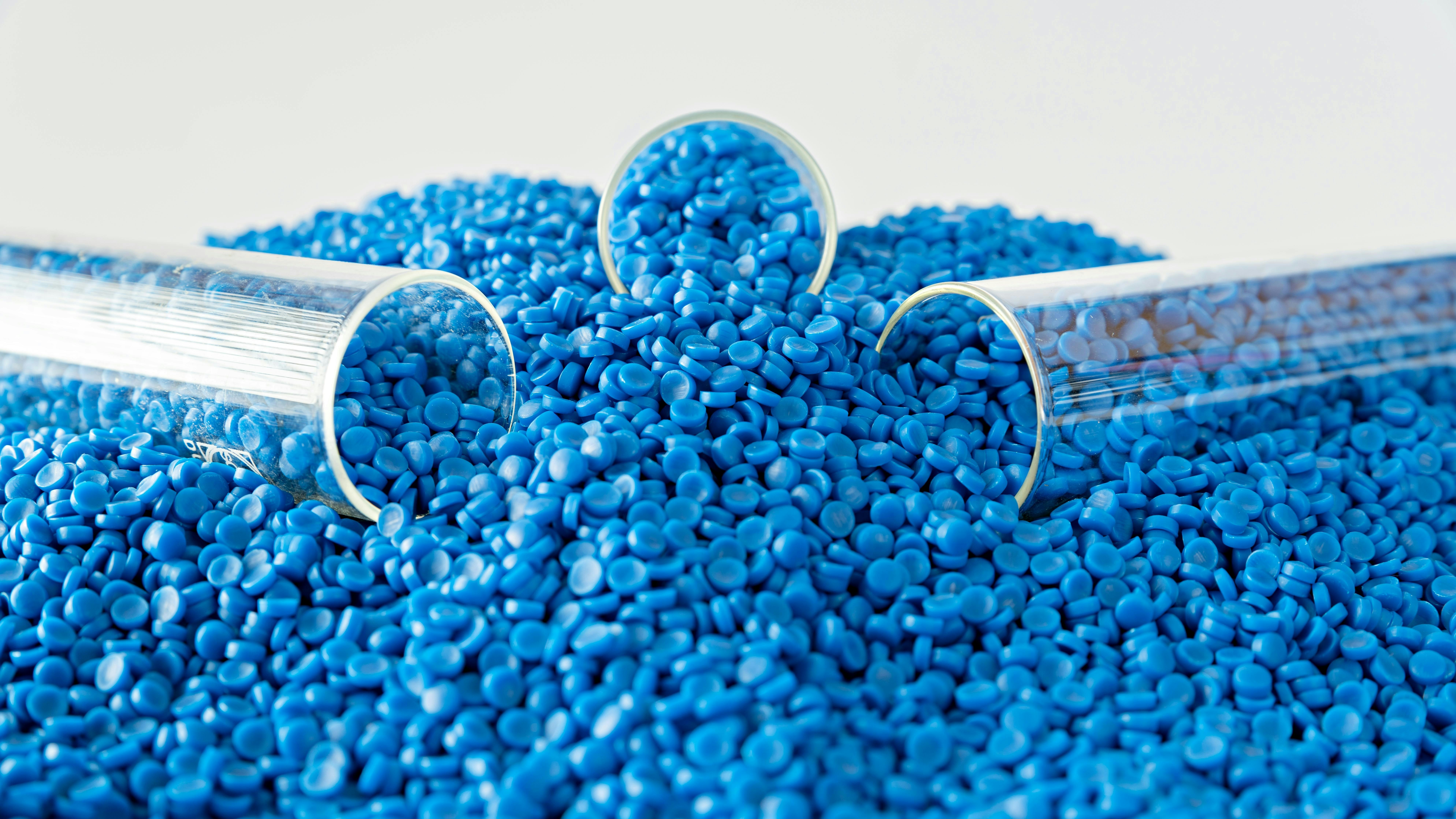 three test test tubes sit in pile of blue plastic pellets