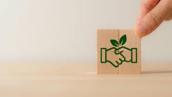 Four wooden blocks stacked together to reveal image of handshake with a green leaf included Four wooden blocks stacked together to reveal image of handshake with a green leaf included