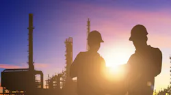 Silhouette of engineer and foreman working at petrochemical oil refinery in sunrise