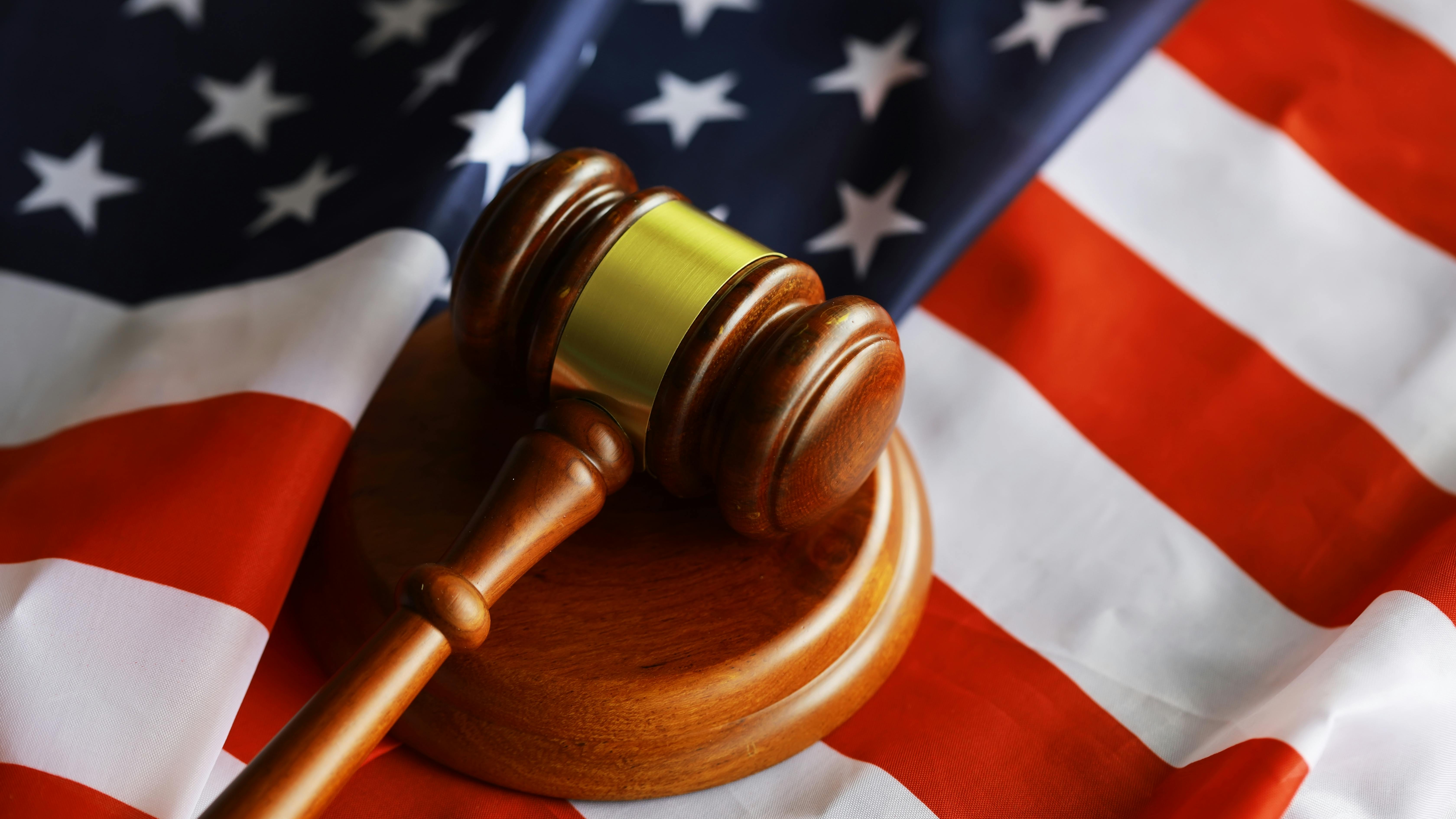 overhead shot of judge's gavel sitting on top of US flag