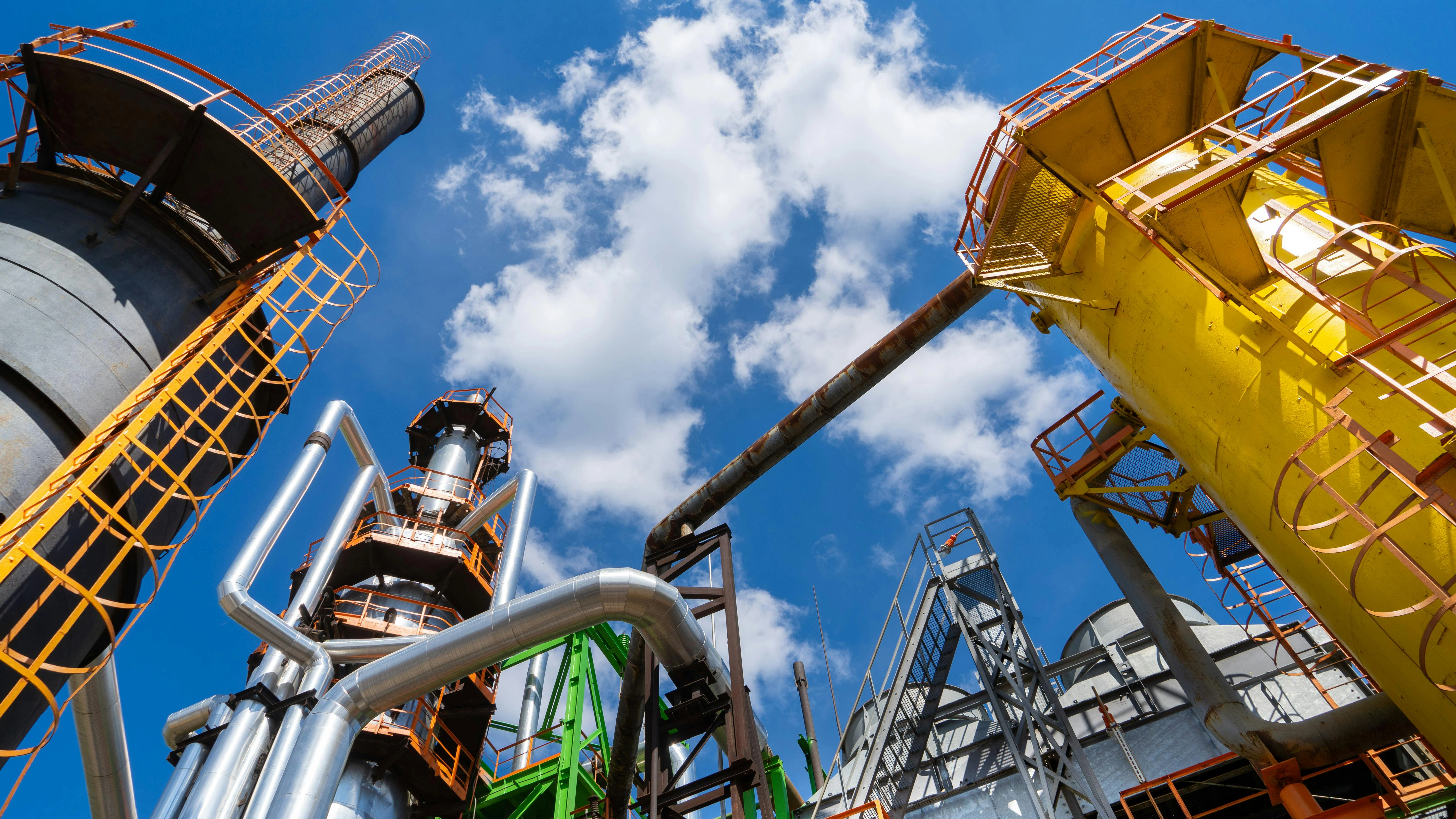 Chemical plant tower with pipes vertical view looking up at sky